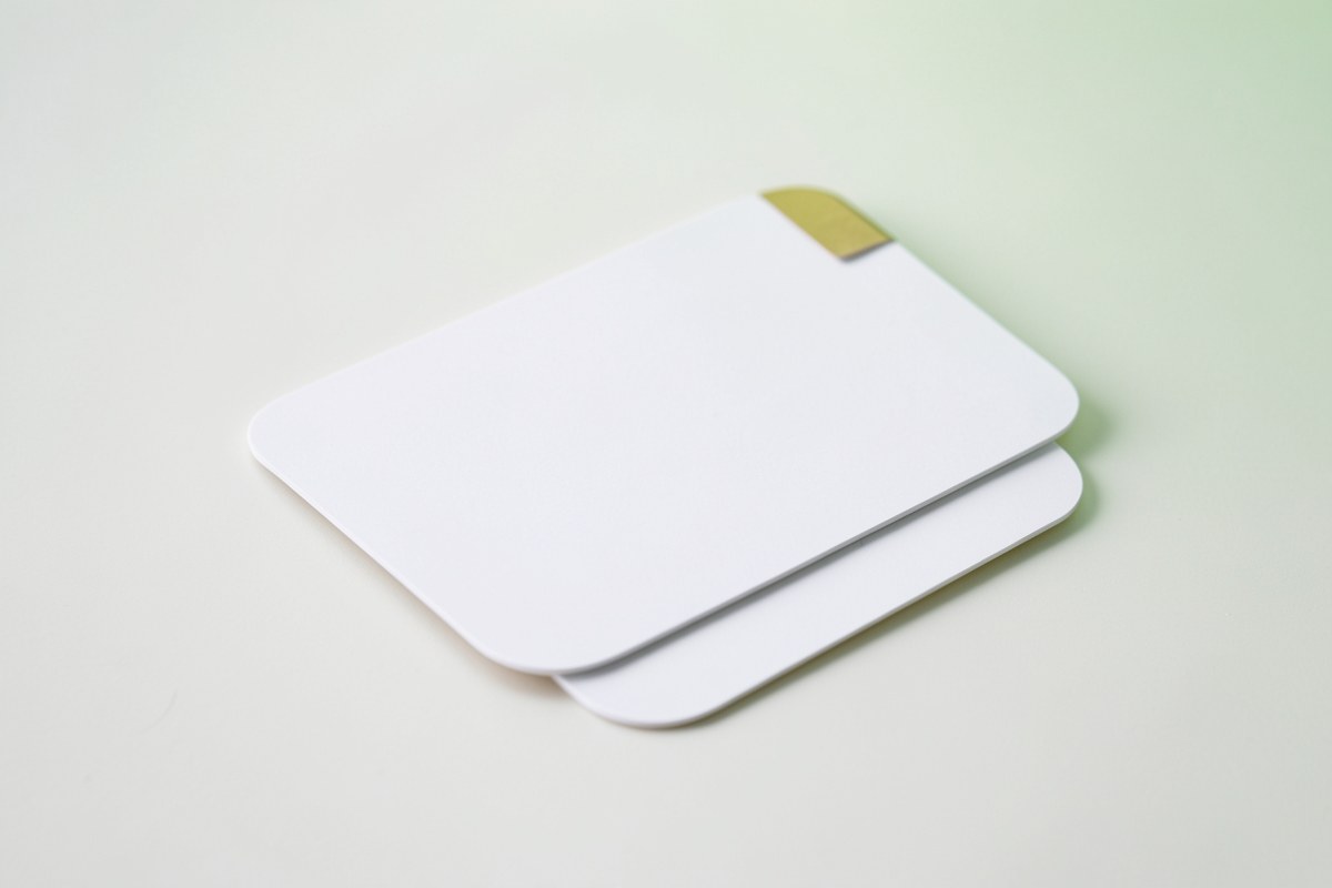 Two overlapping rounded cards on a white surface, one with a subtle gold corner tag, against a soft green background, suggesting a comparison of top loan options.